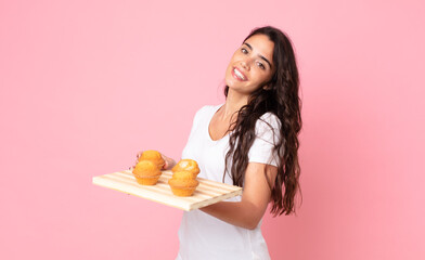 Wall Mural - pretty young woman holding a muffins tray