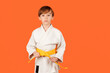 Boy practicing karate on color background, copy space. Kid sport concept. Healthy sporty childhood and lifestyle.