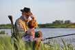 © Roman - family, generation, summer holidays and people concept.nice caucasian grandfather and grandson with fishing rods on river berth. side view, copy space. weekends in nature