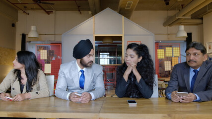 Poster - Closeup shot of Indian business ladies and businessmen having a team meeting