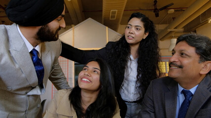 Poster - Closeup shot of Indian business ladies and businessmen having a team meeting