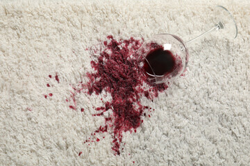 Poster - Overturned glass and spilled red wine on white carpet, top view