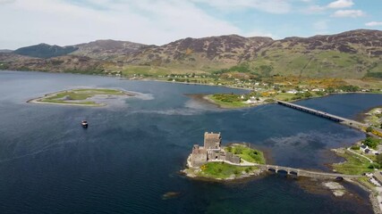 Wall Mural - 4k drone footage of the ancient Eilean Donan Castle overlooking Loch Duich in the Scottish Highlands, UK