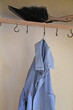 verwaschener blauer Arbeitskittel hängt schlapp an einfachem Garderobenhaken