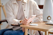 © Roman - Charging mobile phone battery with wireless charging device on table, close-up hands. Smartphone charging on charging pad. Mobile phone near wireless charger. Copy space