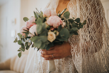 Canvas Print - Unrecognizable bride holding a beautiful bridal bouquet in her bedroom