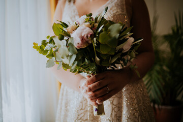 Canvas Print - Unrecognizable bride holding a beautiful bridal bouquet in her bedroom