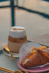 Sticker - Glass of Latte macchiato coffee and a piece of croissant on the table