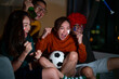 © CandyRetriever  - Group of Asian people friends sit on sofa watching and cheering sports games competition on TV together at home. Excited man and woman sport fans celebrate sport team victory in national sports match