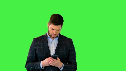 Cheerful young man in formal wear chat in mobile phone app happy Businessman read sms in smartphone on a Green Screen, Chroma Key.