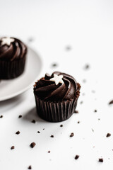 Wall Mural - Vertical shot of chocolate cupcake with star topping on white background