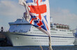 Classic British cruiseship cruise ship liner docked in Tilbury, London UK on River Thames seen from excursion boat with flying flag Union Jack