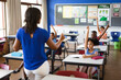 © WavebreakMediaMicro - Rear view of african american female teacher teaching students in the class at elementary school