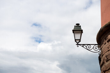 Wall Mural - Closeup of vintage street light in the street on cloudy sky background