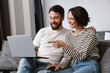 © Drobot Dean - Happy young white couple looking at laptop computer