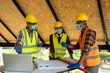© visoot - Engineers or architect holding a pen with drawings in construction on blueprints in construction site for discussing,Engineering tools and construction concept.