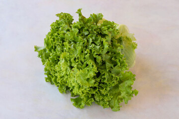 Curly lettuce on a white wooden background