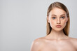© LIGHTFIELD STUDIOS - young woman with bare shoulders and blue eyes isolated on grey