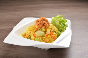 Wall Mural - Thai golden pineapple wok fried rice with chicken floss on wood table asian halal menu