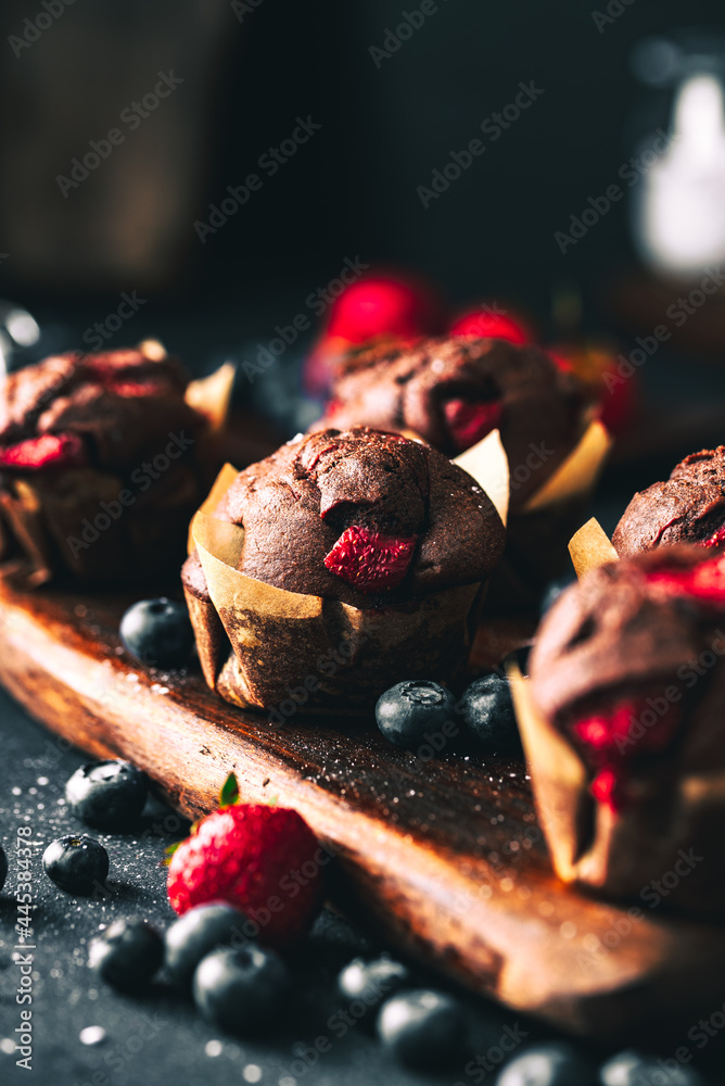 Muffin. Chocolate muffins with stawberry. Muffins on wooden stand. - obrazy, fototapety, plakaty 
