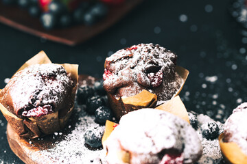 Wall Mural - Muffin. Chocolate muffins with stawberry. Muffins on wooden stand with powder sugar.