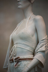 Wall Mural - Closeup of beige sulmer clothes on mannequin in a fashion store showroom