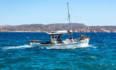 Wall Mural - Fishing boat moving in wavy sea. Cyclades Greece