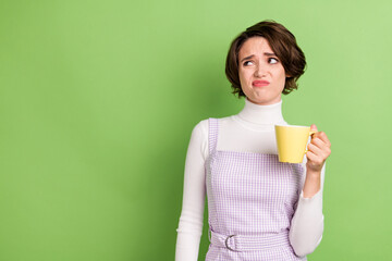 Photo portrait woman upset keeping cup with tea looking copyspace isolated pastel green color background