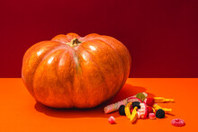 Studio Shot Of Raw Pumpkin And Halloween Candies