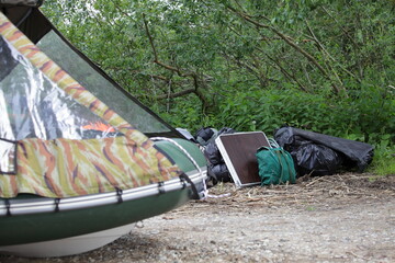 Wall Mural - Tourists equipment pile on Modern new awning RIB inflatable PVC boat background at summer day, outdoor recreation activities on the nature