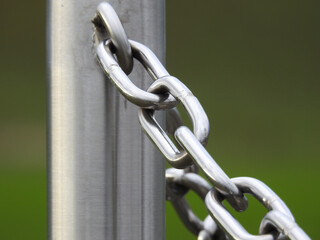 Wall Mural - Selective focus shot of a chain attached to a metal pole