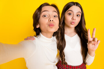 Poster - Photo portrait of small kids taking selfie showing v-sign gesture sending air kiss isolated on bright yellow color background