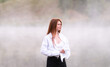 © deine_liebe - Beautiful red-haired girl on a background of white morning fog. Dawn over the lake. Yellow summer sunrise.