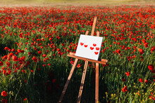 Painted Poppy Flowers Canvas On Easel Amidst At Field