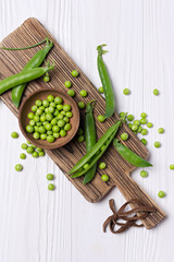 Wall Mural - Fresh green peas in bowl on wooden board