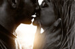 Couple in love kissing on sunset - Boyfriend and girlfriend hugging outdoor - Two lovers having romantic date - Black and white filter - Love background concept