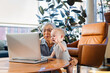© Cavan Images - Senior woman sitting with granddaughter using laptop to video call