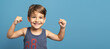 © Miljan Živković - Front view of small caucasian boy four years old standing in front of blue background studio shot standing confident flexing muscles smiling growing up and strength and health concept