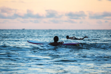 Poster - Scenic view of surfers entering the ocean to surf huge waves during a beautiful sunset