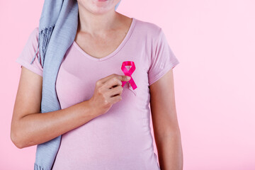 a asian women disease mammary cancer patient in pullover holding pink ribbon isolated on pink blank copy space studio background,healthcare,medicine concept