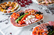 A plate with different appetizers, with all kinds of sausages, cheeses and vegetables at an event. waiter