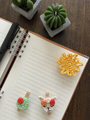 Poster - Vertical shot of a blank notepad with space for text on the table with brooches and pins on it