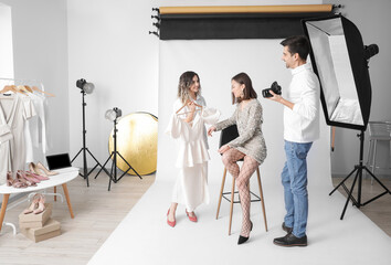 Poster - Stylist and photographer working with model in studio