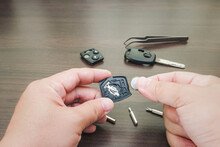 Hand A Man Change Batteries Of Car Key And Repair Concept On Wood Table Background With Screwdrivers And Pliers