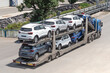 Car carrier trailer transporting new automobiles on road