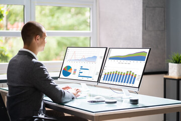 Poster - Businessman In Office At Desk Using Graphs