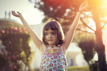 Wall Mural - Little girl having fun outdoors in sunset