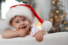 Cute Little Baby Wearing Santa Hat At Home. Christmas Celebration