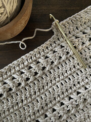 Poster - Top view of skeins, cotton yarn, crochet needle and knit knitting tools on a brown wooden background