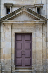 Poster - Vertical shot of an old door on a stone wall building in Guimaraes, Portugal